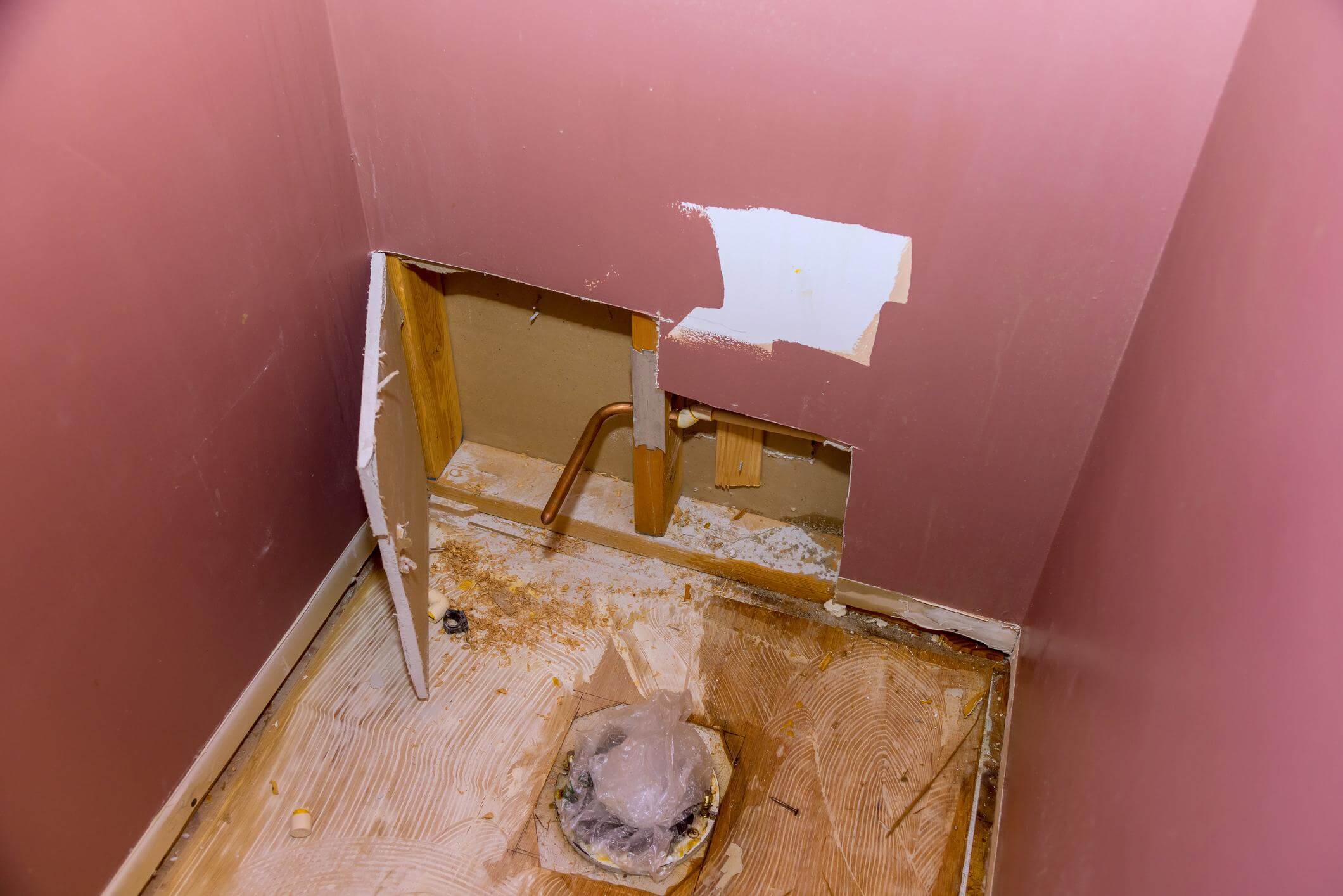 Bathroom plumbing access and rough condition before renovation