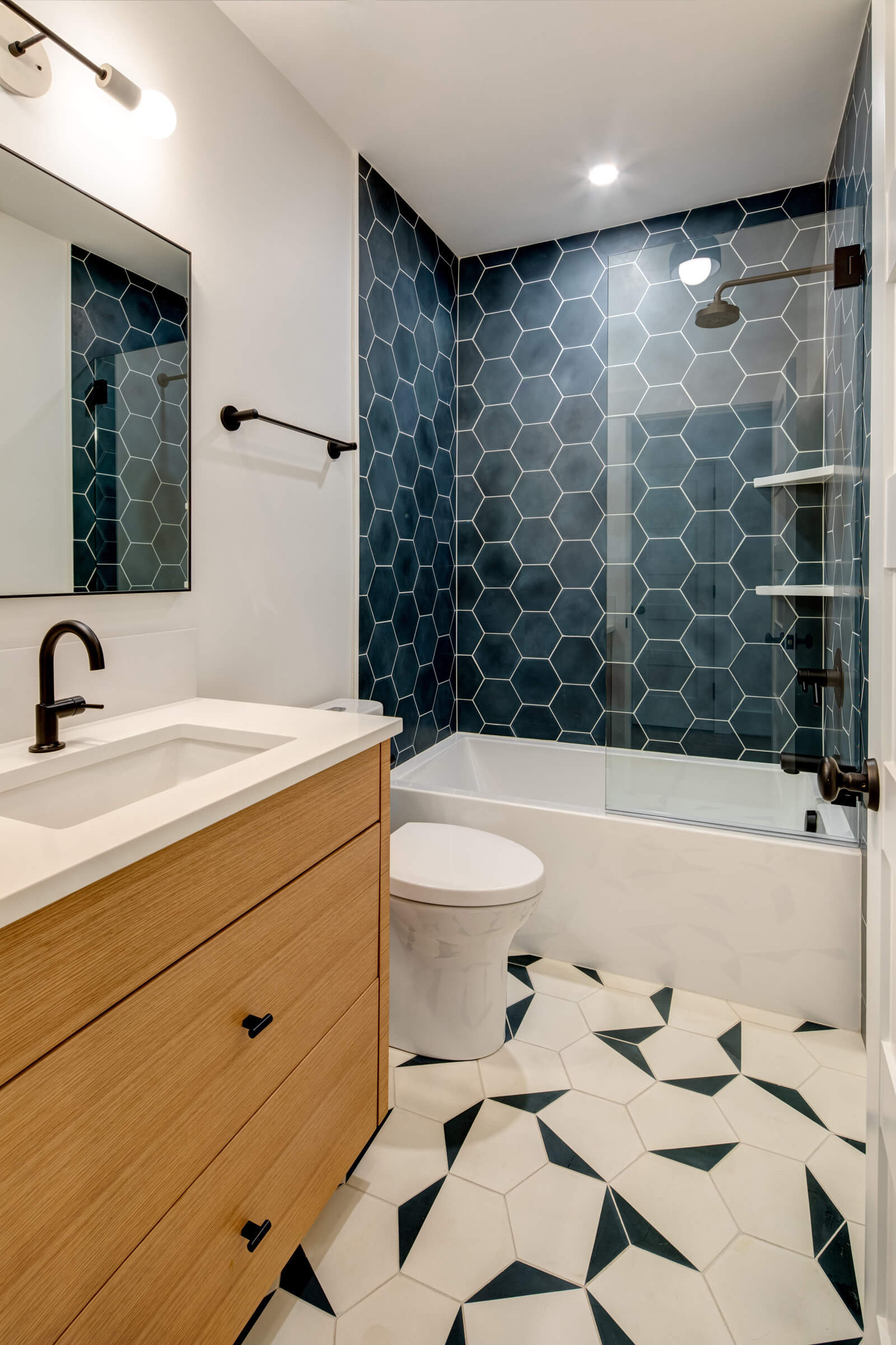 Bathroom renovation Worcester MA with blue hex tile wall and wood vanity